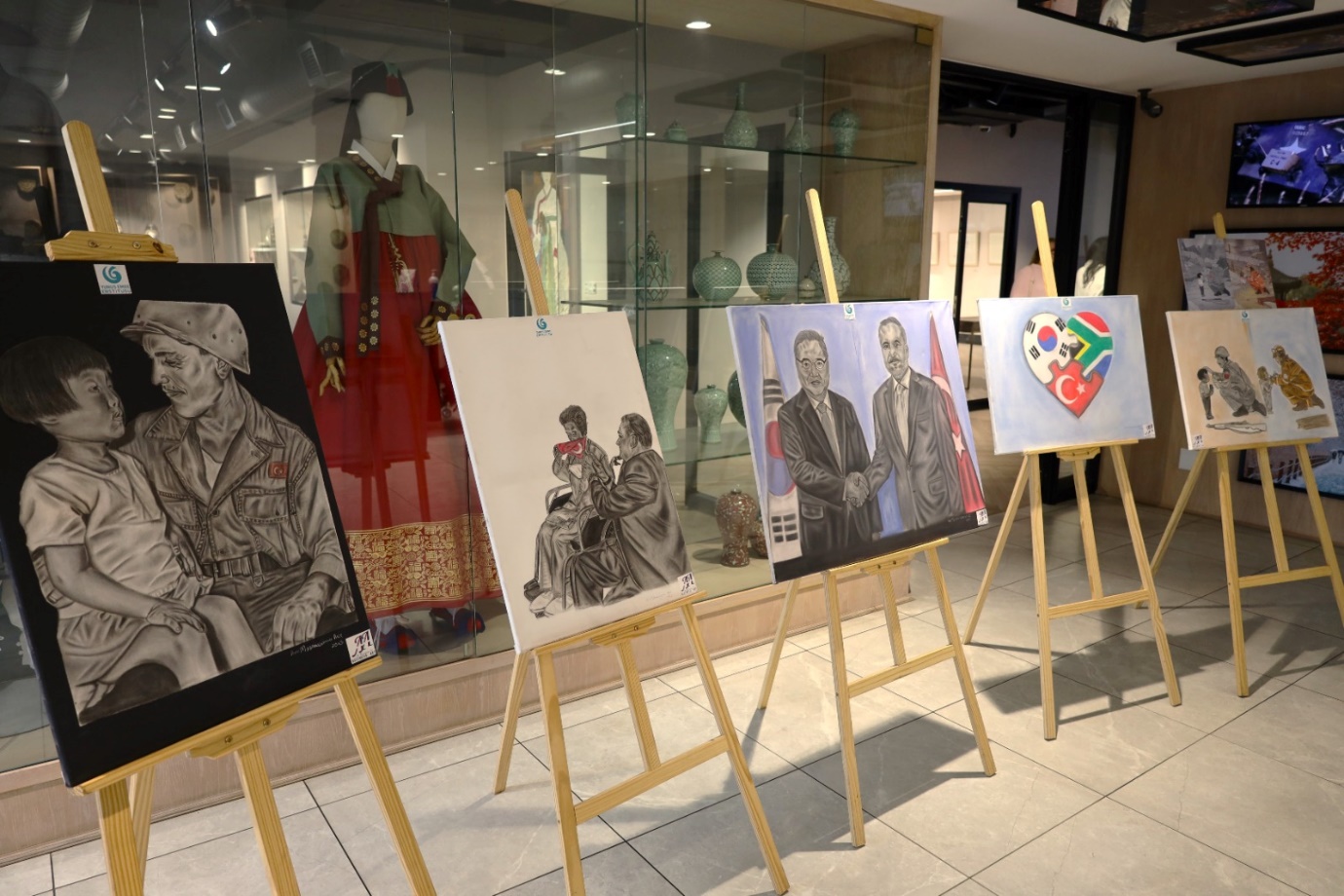 Several easels with paintings on them

Description automatically generated