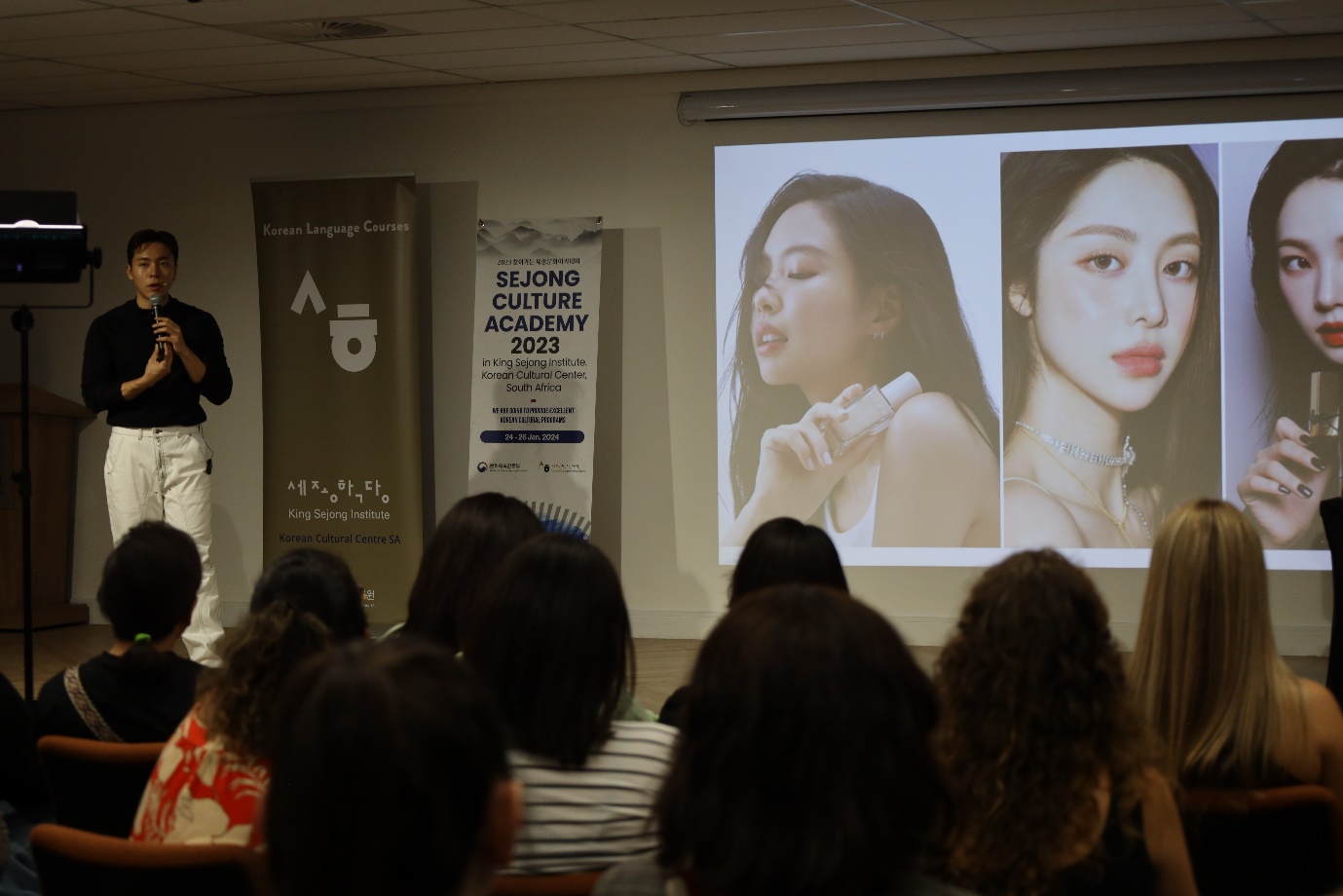 A person giving a presentation to a group of people
Description automatically generated