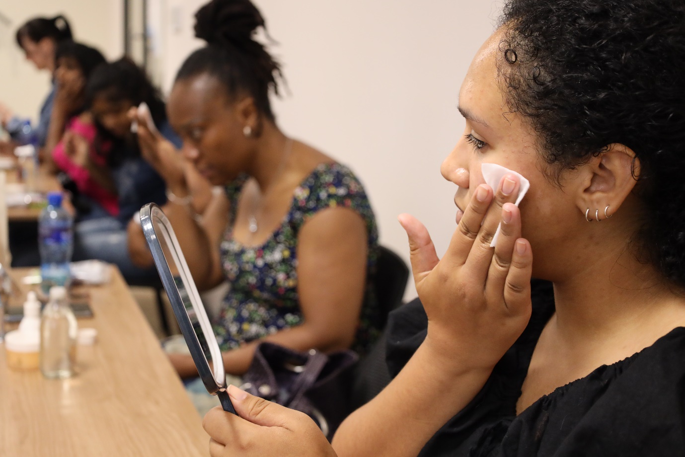 A person applying makeup on her face

Description automatically generated