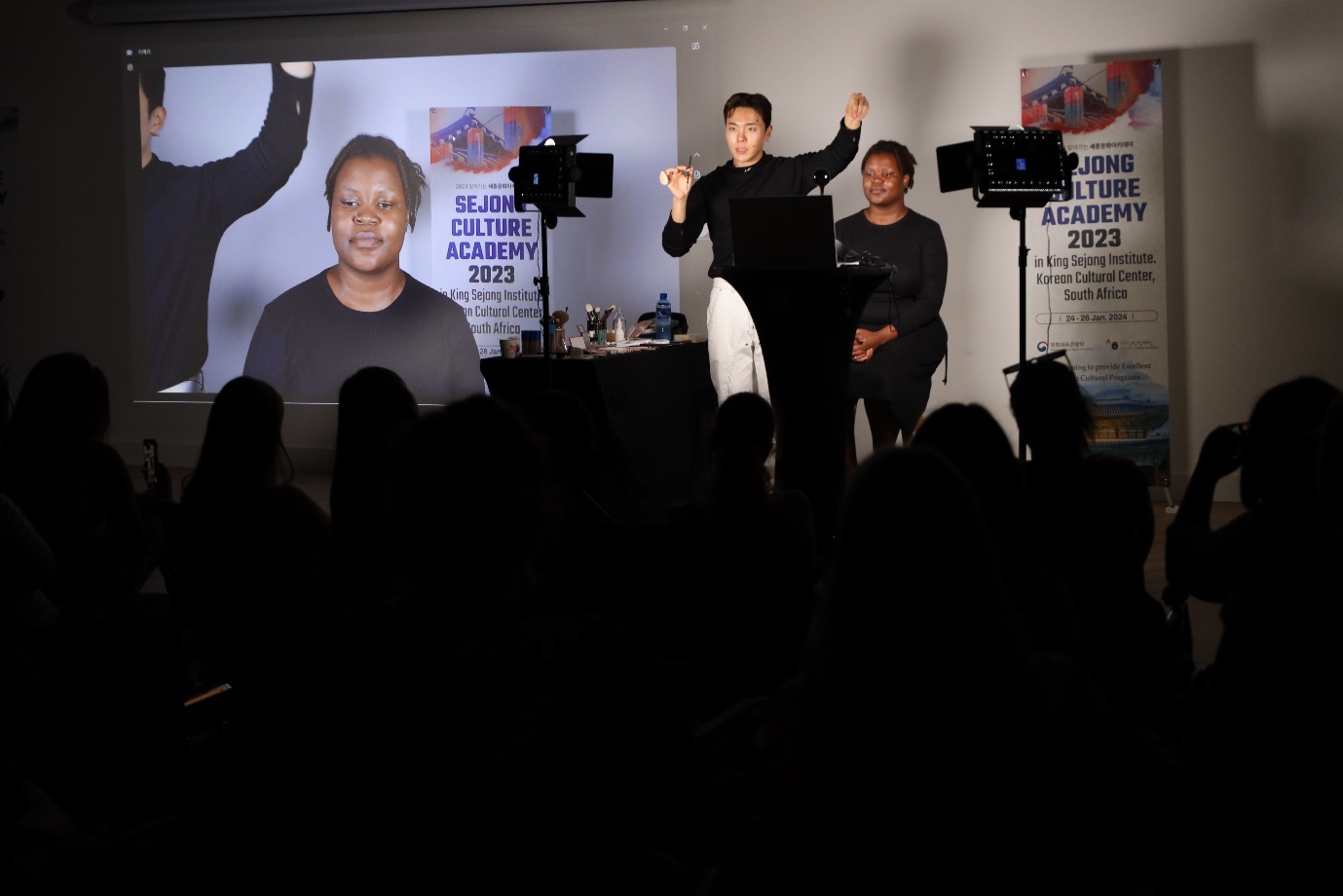 A group of people standing in front of a screen

Description automatically generated