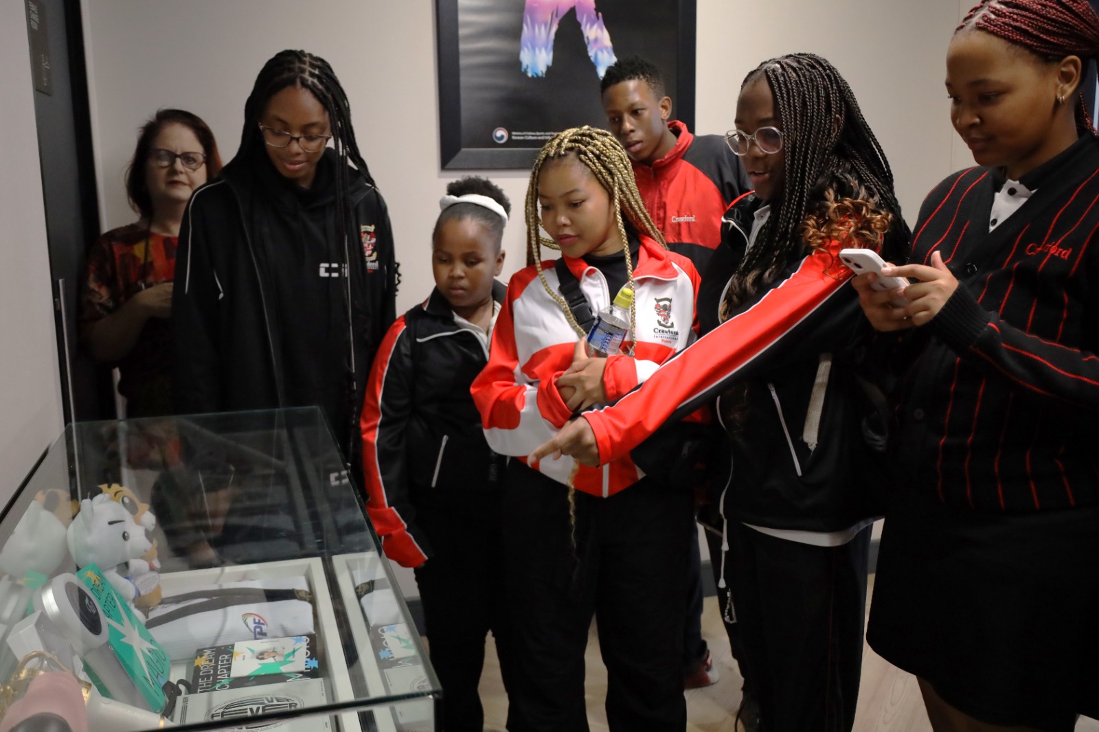 A group of people standing around a glass case

Description automatically generated