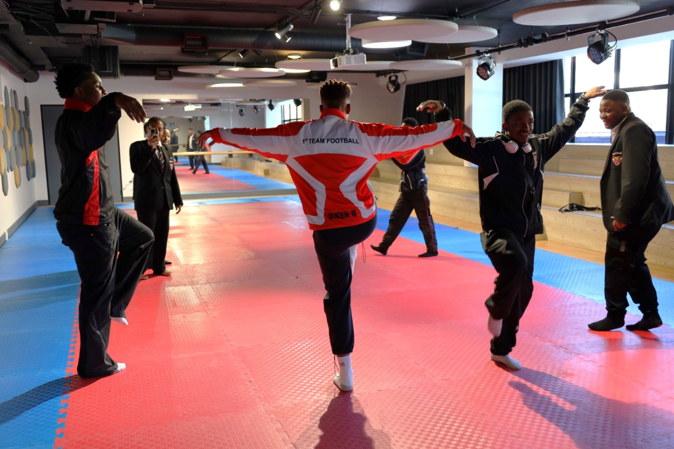 A group of people dancing in a gym

Description automatically generated