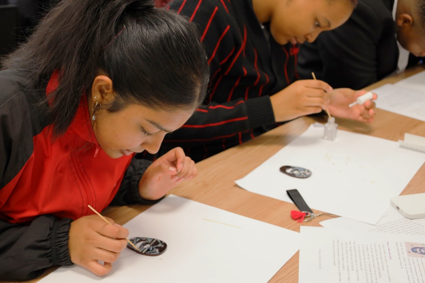 A young person painting on paper

Description automatically generated