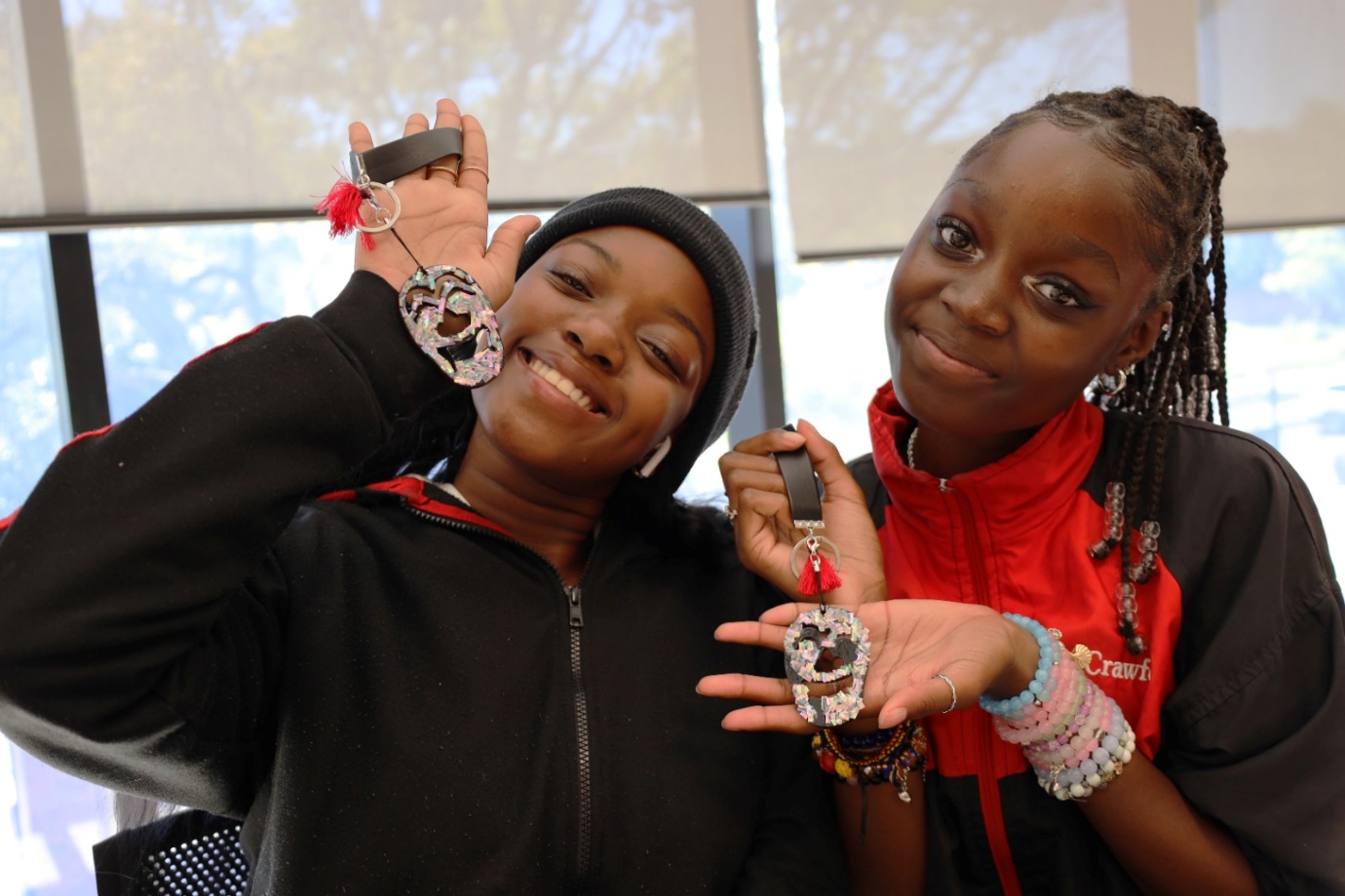 A couple of young women holding medals

Description automatically generated