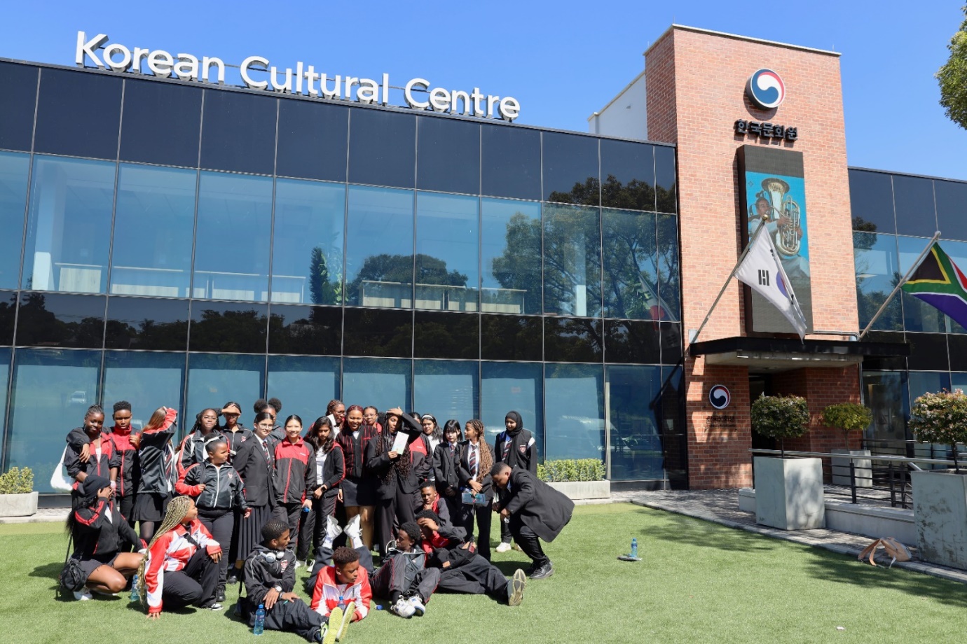 A group of people in black and red uniforms outside of a building

Description automatically generated
