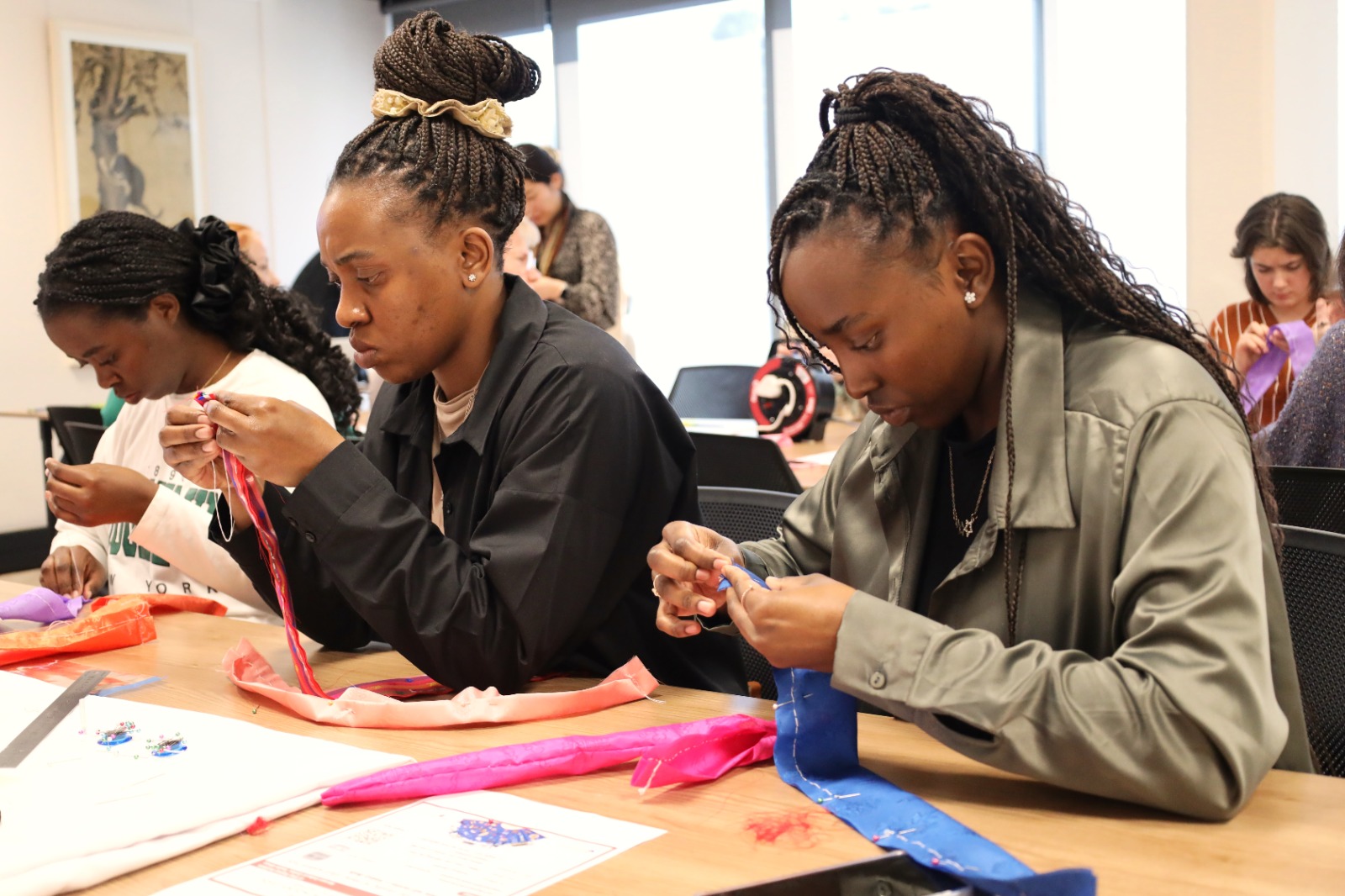 A group of women working on crafts

Description automatically generated