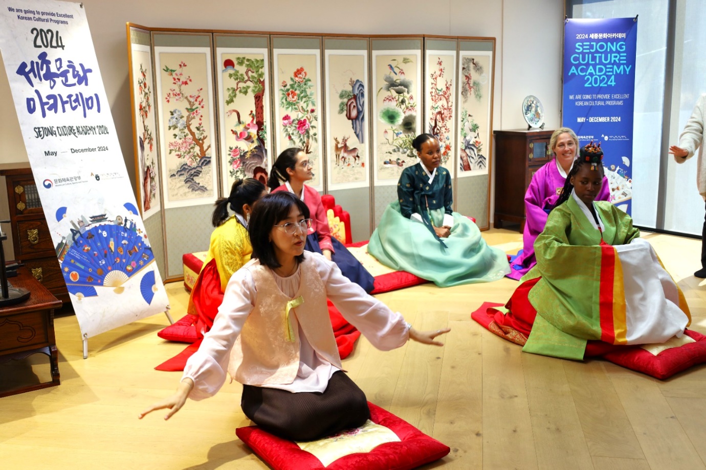 A group of women sitting on the floor

Description automatically generated