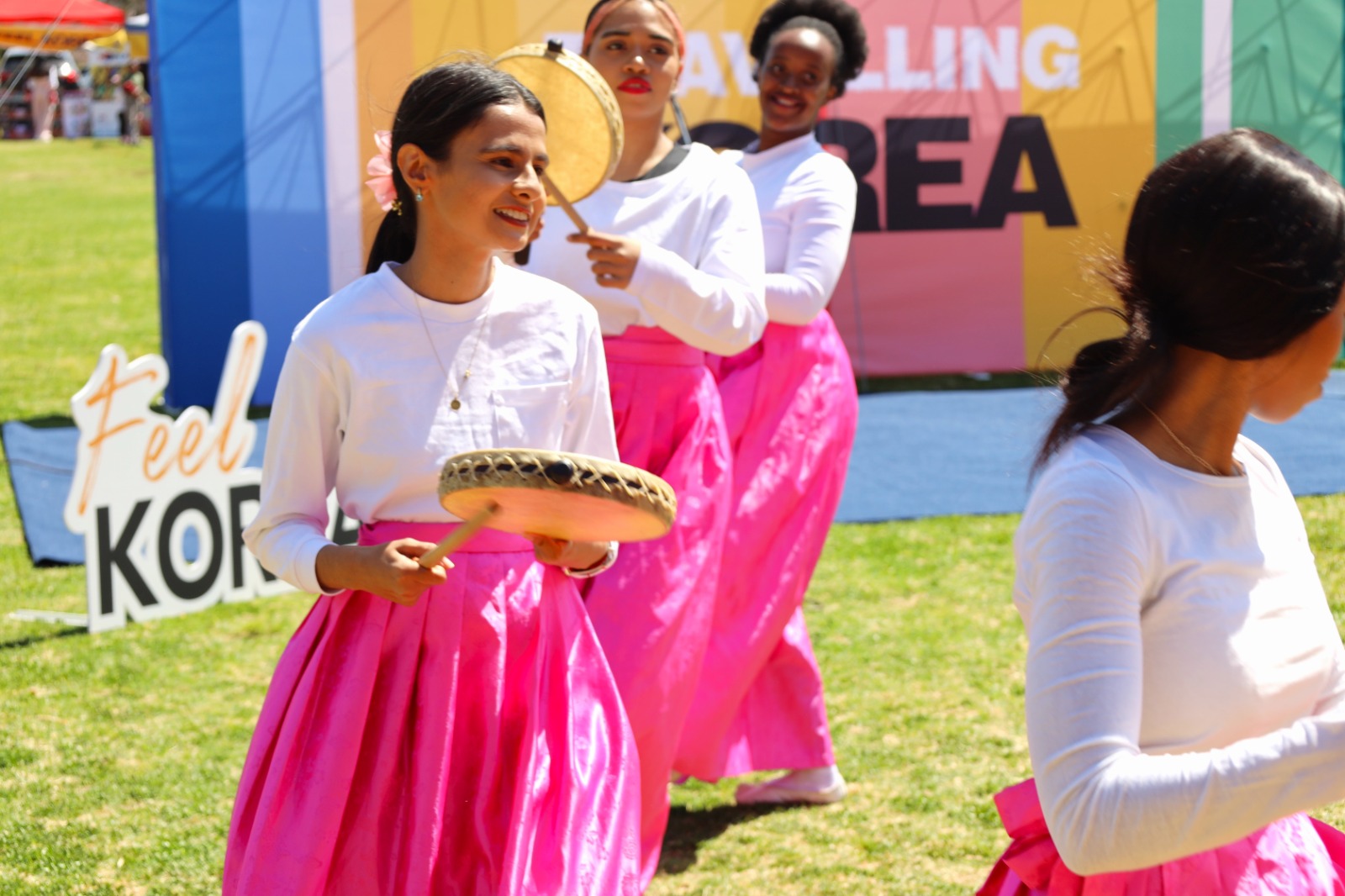 A group of women in pink skirts

Description automatically generated