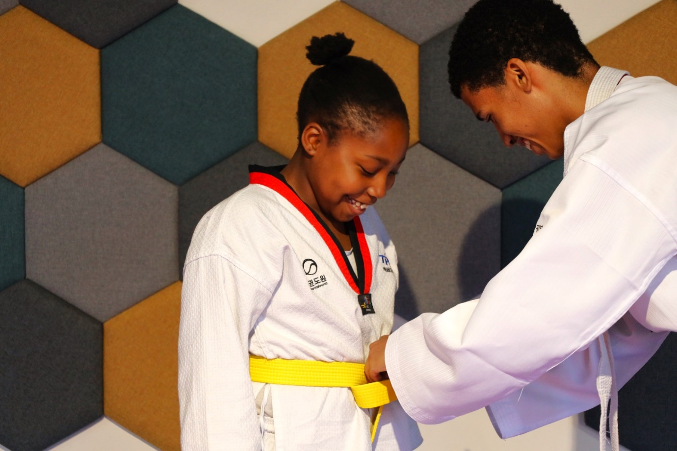 A person and person in karate uniform

Description automatically generated