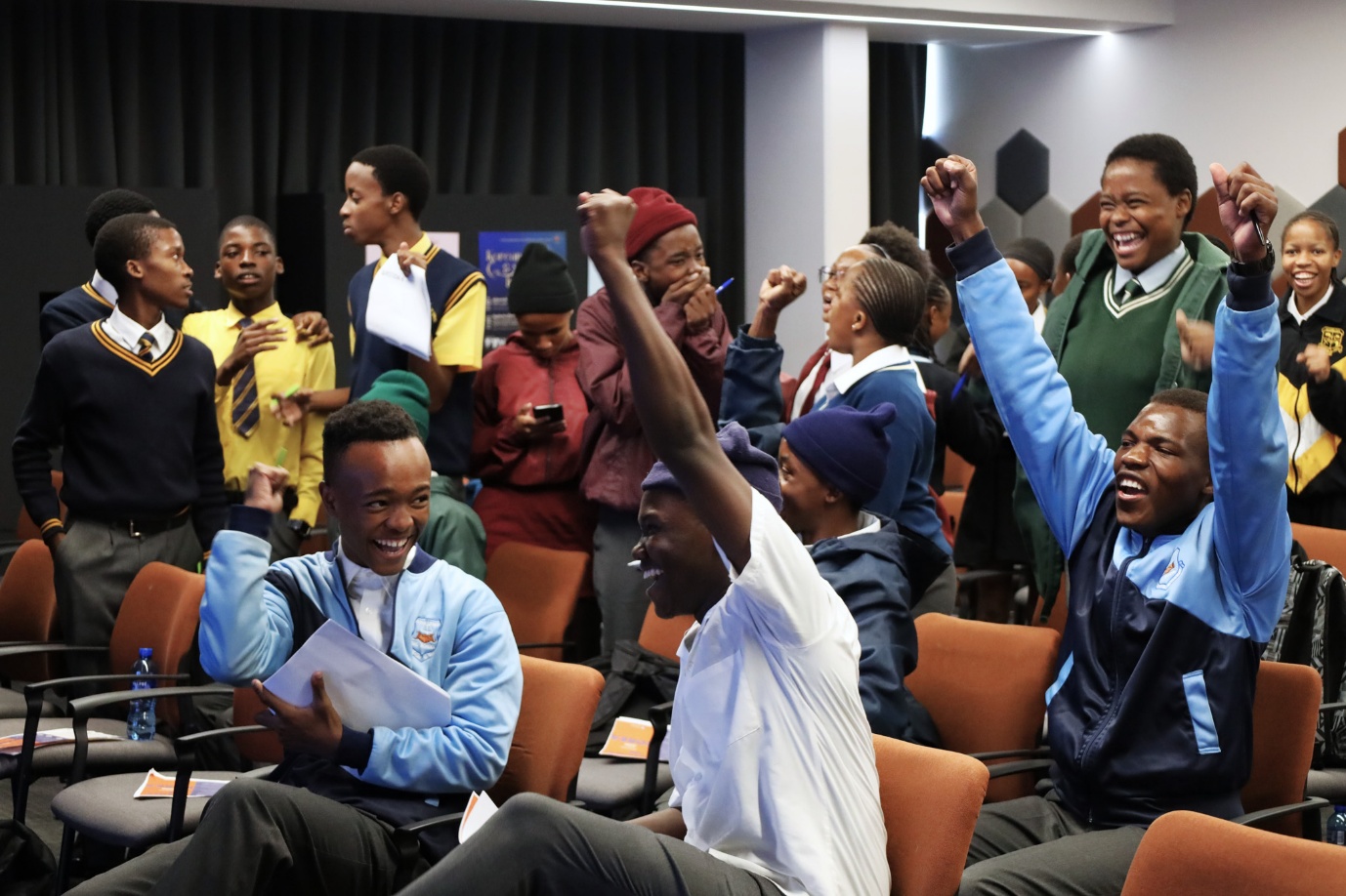 A group of people cheering in a room

AI-generated content may be incorrect.