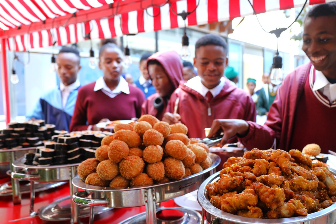 A group of people standing behind a table full of food

AI-generated content may be incorrect.