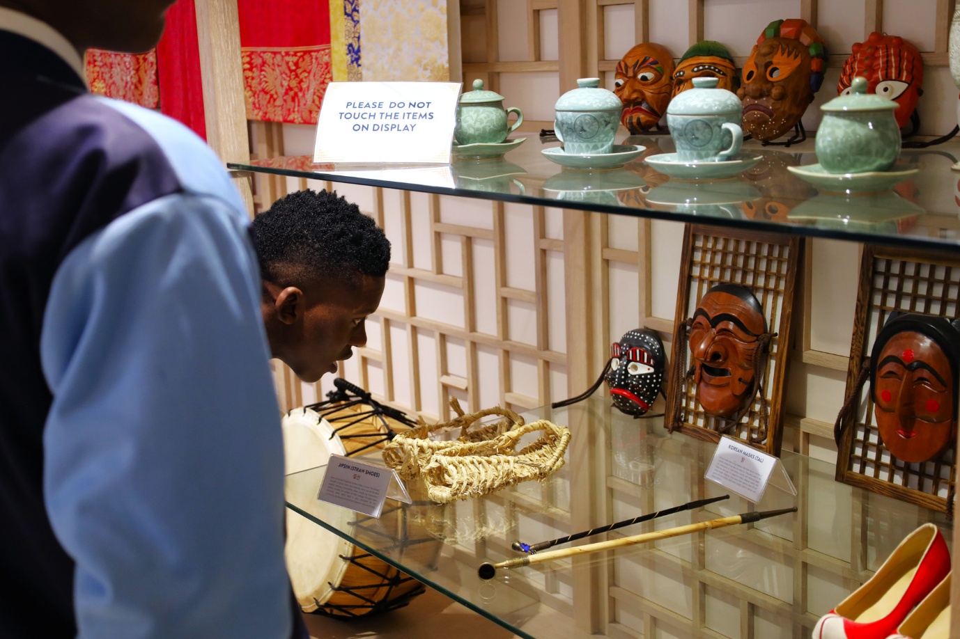 A child looking at objects on a glass shelf

AI-generated content may be incorrect.