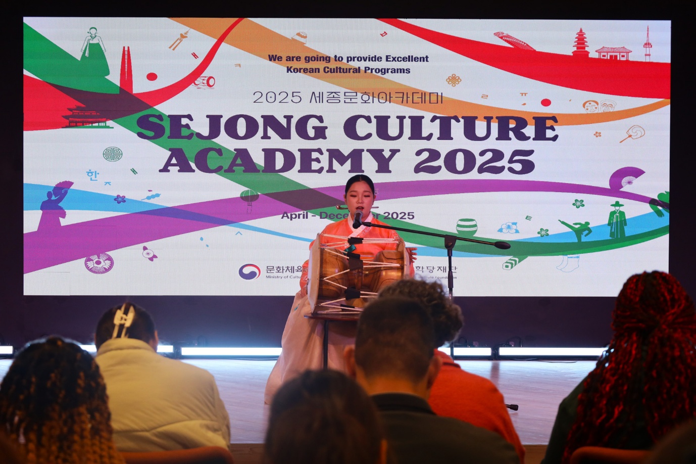 A person standing at a podium with a crowd of people watching
AI-generated content may be incorrect.