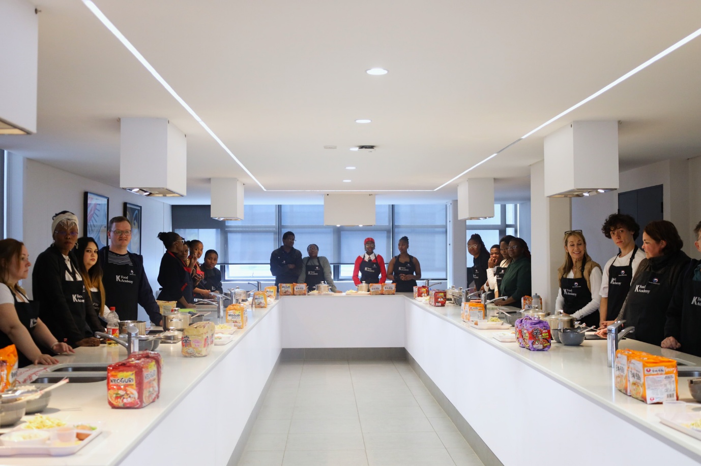 A group of people standing in a kitchen
AI-generated content may be incorrect.