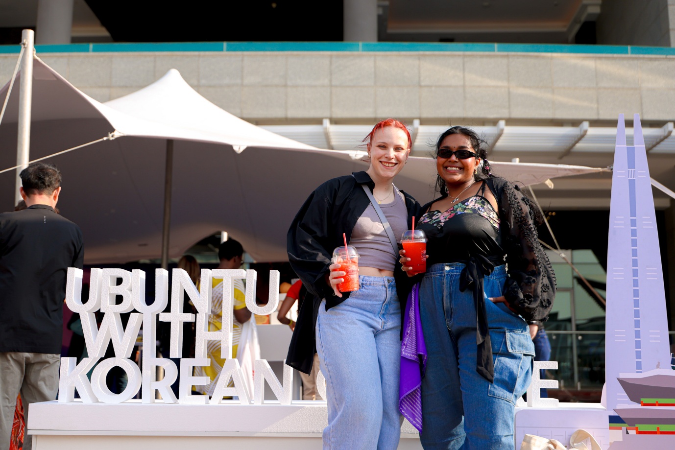 A couple of women standing in front of a sign

AI-generated content may be incorrect.