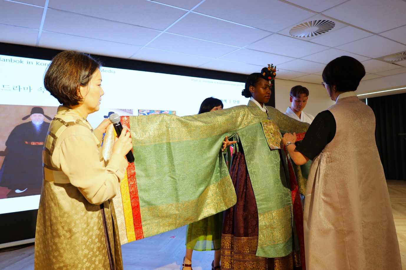 A group of women holding a green and gold dress
AI-generated content may be incorrect.
