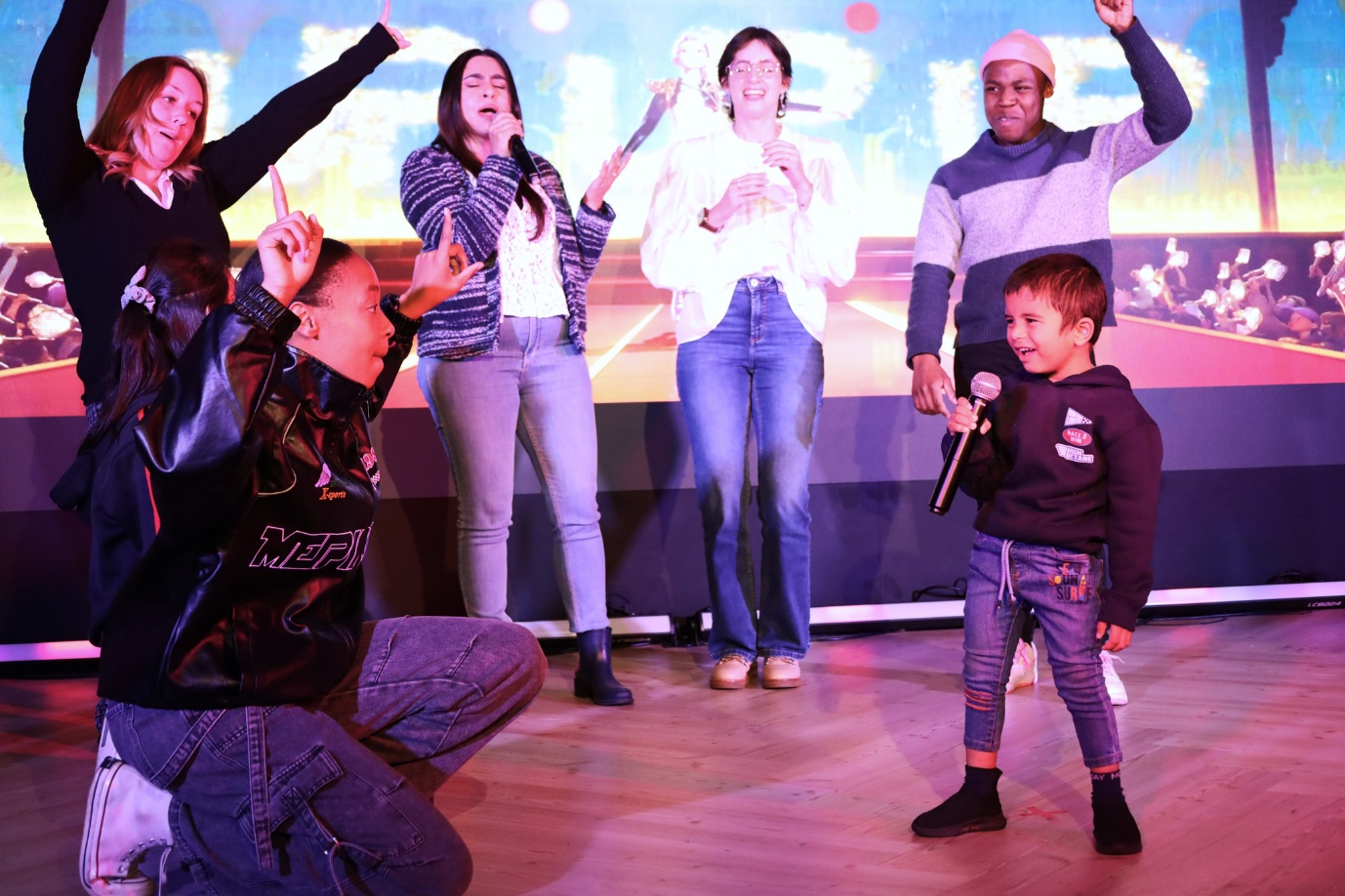 A group of people singing on stage

AI-generated content may be incorrect.