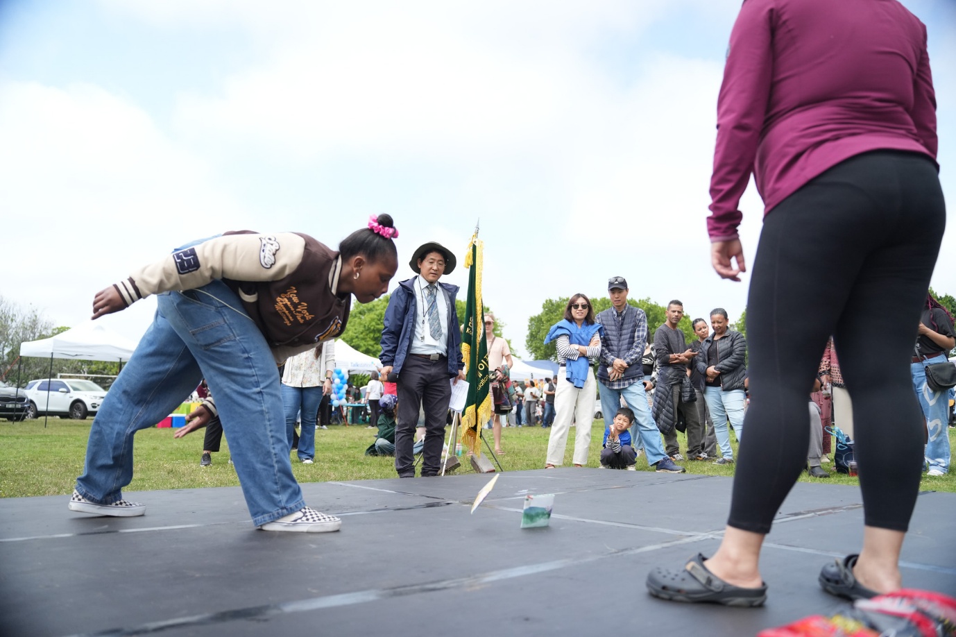 A person in a brown shirt and blue jeans bending over to throw a cup

AI-generated content may be incorrect.