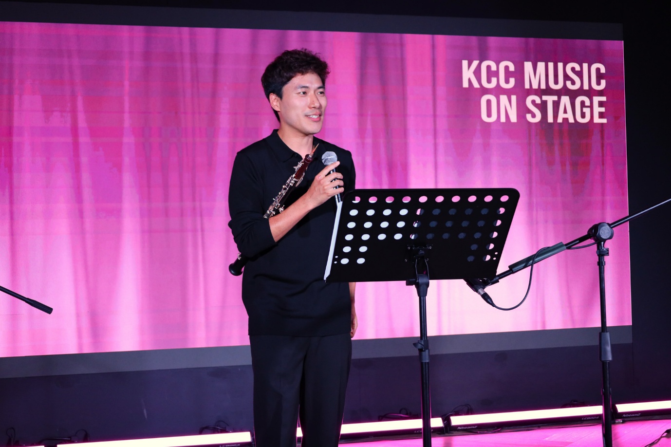 A person holding a microphone and standing on a stage

AI-generated content may be incorrect.